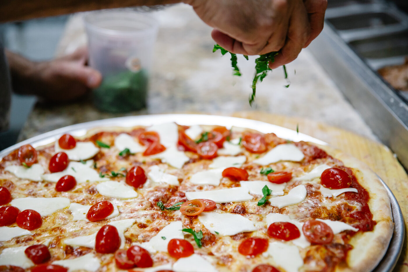 Margherita pizza getting fresh basil