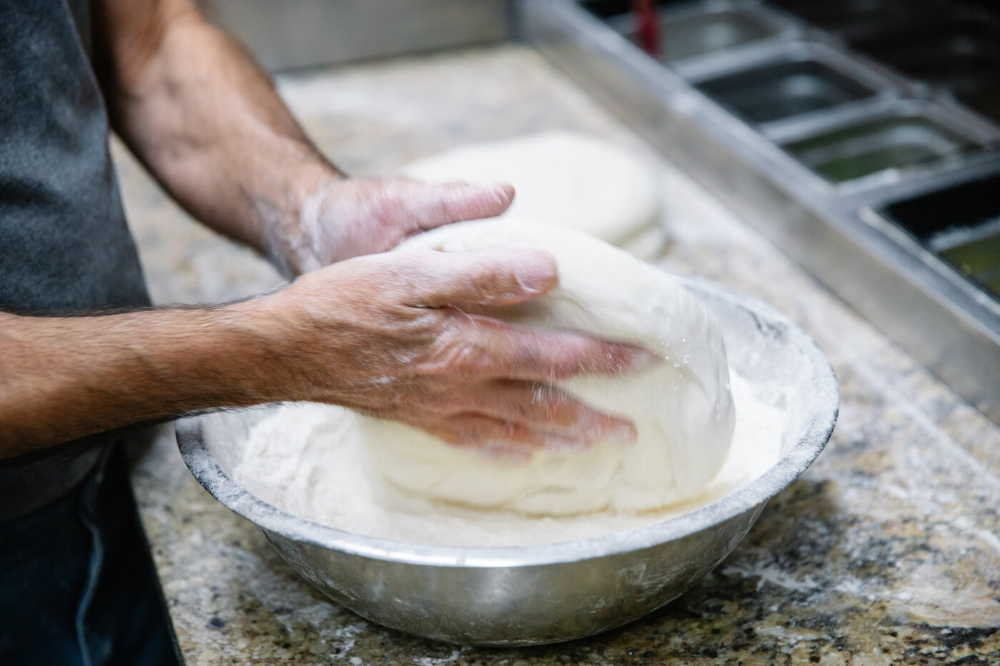 Hand-kneading fresh pizza dough